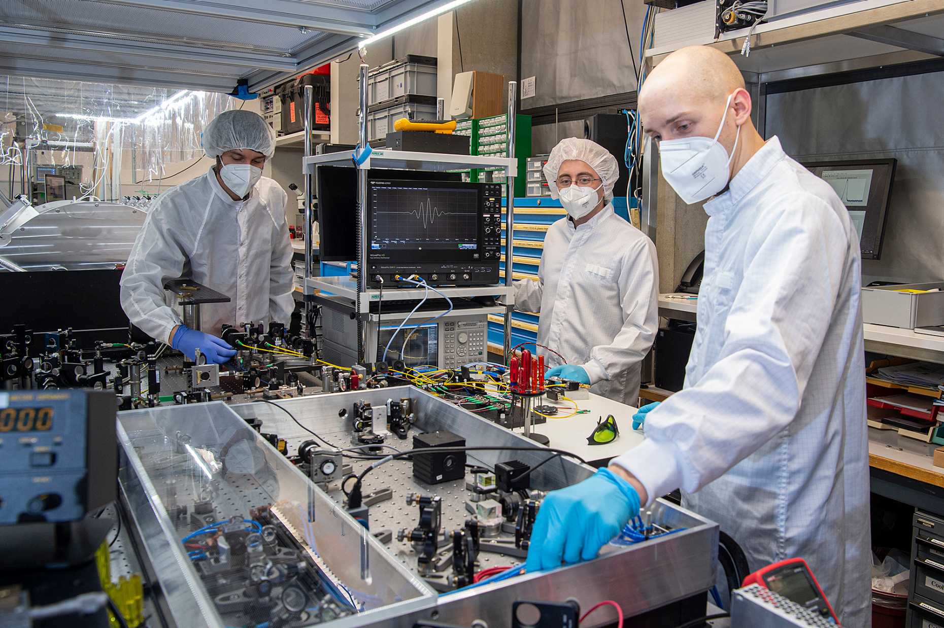 Die Teammitglieder Benjamin Willenberg, Justinas Pupeikis und Christopher Phillips bei der Arbeit mit dem Doppelkamm-Laser im Ultrafast Laser Physics Labor (Foto: ETH Zürich/D-PHYS/Heidi Hostettler)