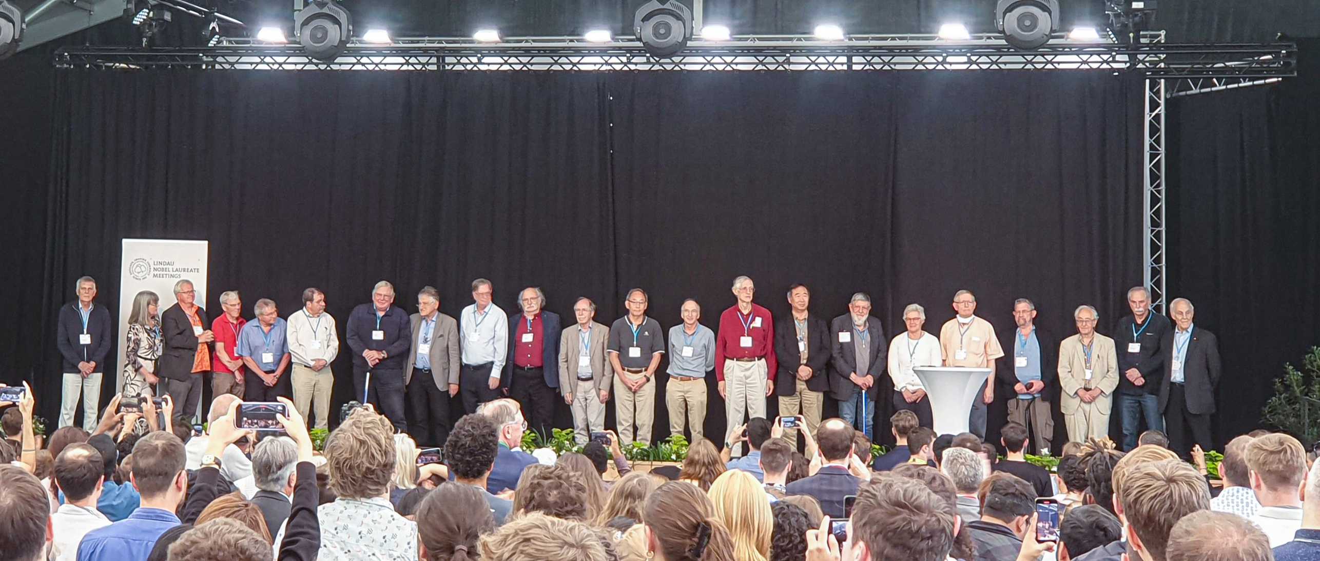 Nobel laureates standing together on a ceremony stage