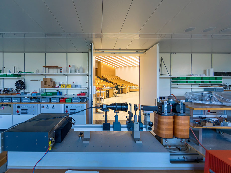 Lecture theatre seen from a room full of equipment for demonstration experiments